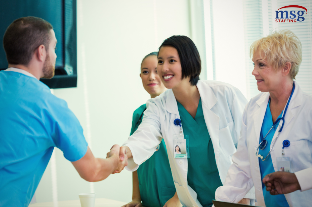 Female doctors shaking hands with male nurse